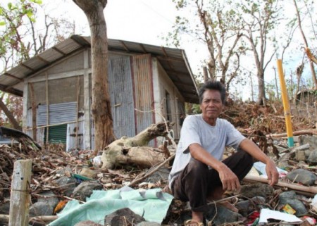 Philippines-2013-Hurrican-Haiyan-Sefin-Arabaca-outside-his-destroyed-house-570x407